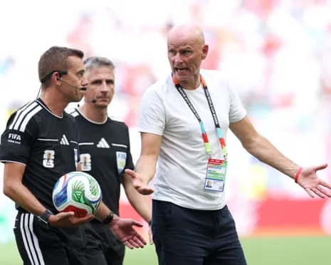 Ståle Solbakken complains to Clément Turpin, the referee, as the Norway coach and the officials leave the pitch at half-time